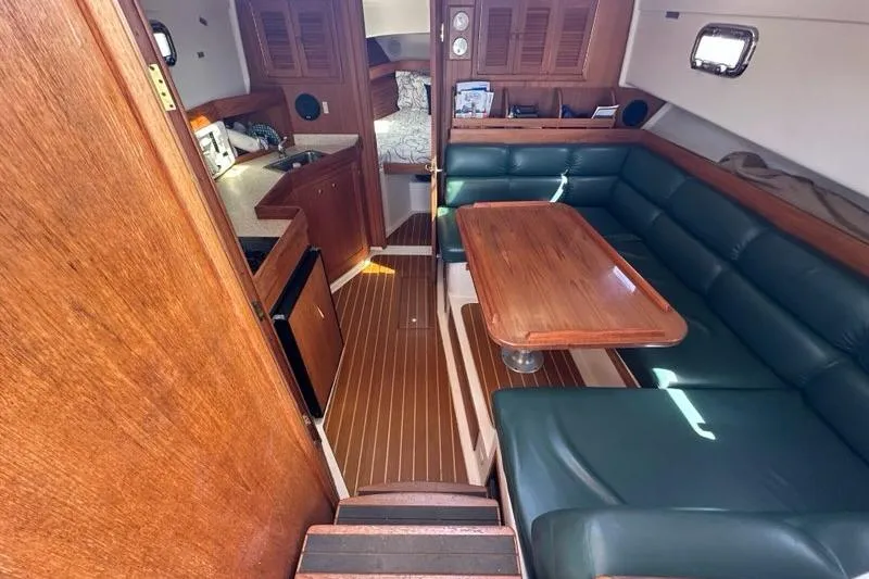 Slide: The Image of Interior of 2002 Mainship Pilot 34 with wood finishes and green seating. - 17