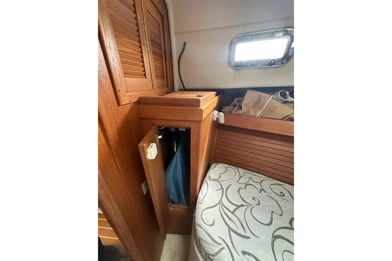 Slide: The Image of 2002 Mainship Pilot 34 cabin interior with wooden cabinetry and patterned upholstery. - 26