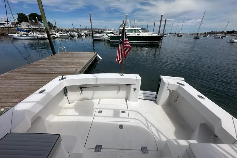 Slide: The Image of 2002 Mainship Pilot 34 at dock, American flag, marina view, clear sky. - 39