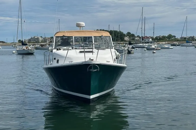 Slide: The Image of 2002 Mainship Pilot 34 boat in a scenic harbor with sailboats. - 6