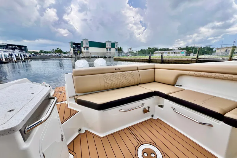 Slide: The Image of 2019 Sea Ray SDX 290 Outboard with tan seating, docked by the waterfront. - 12