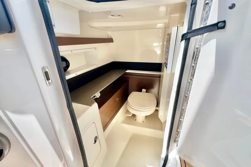 Slide: The Image of 2019 Sea Ray SDX 290 Outboard boat interior bathroom with toilet and storage. - 17