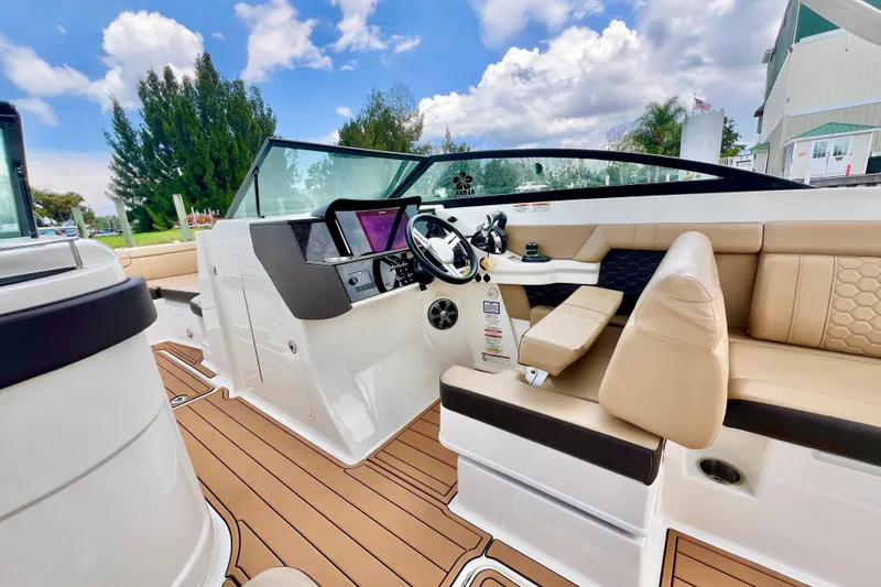 Slide: The Image of 2019 Sea Ray SDX 290 Outboard interior with beige seating and modern dashboard. - 20