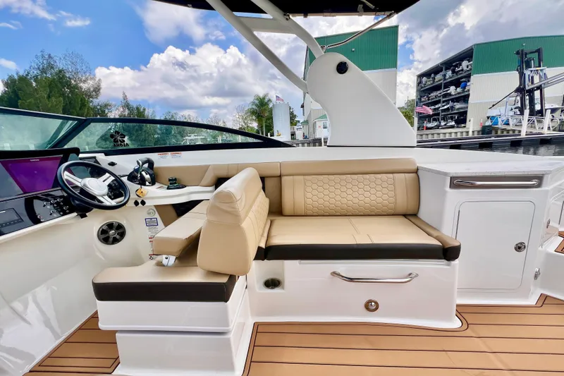 Slide: The Image of 2019 Sea Ray SDX 290 Outboard interior with beige seating and modern dashboard. - 26