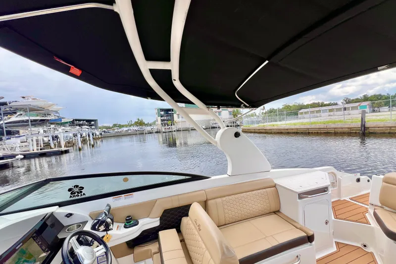 Slide: The Image of 2019 Sea Ray SDX 290 Outboard boat interior with black canopy and beige seating. - 27