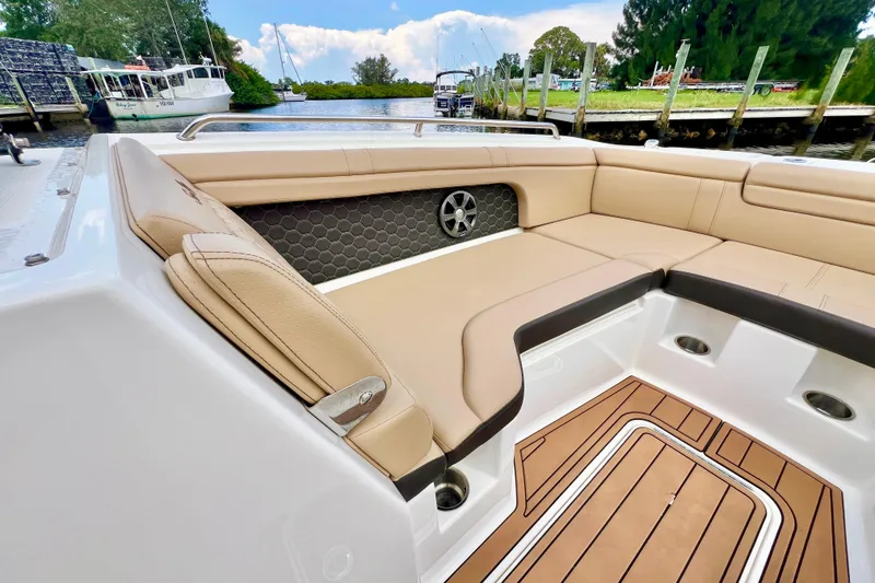 Slide: The Image of 2019 Sea Ray SDX 290 Outboard boat interior with tan seating and wood-style flooring. - 28