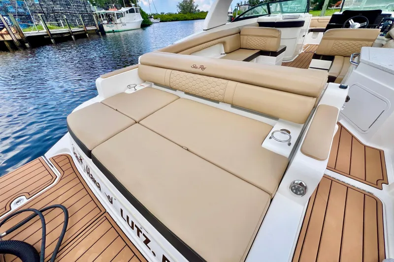 Slide: The Image of 2019 Sea Ray SDX 290 Outboard boat with tan seating and teak flooring by the water. - 9