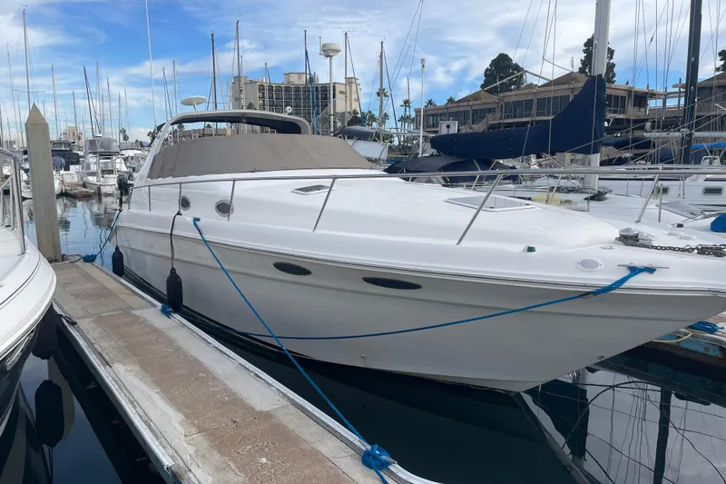 The Image of 1999 Sea Ray 330 Sundancer yacht docked in marina, surrounded by other boats. - 0