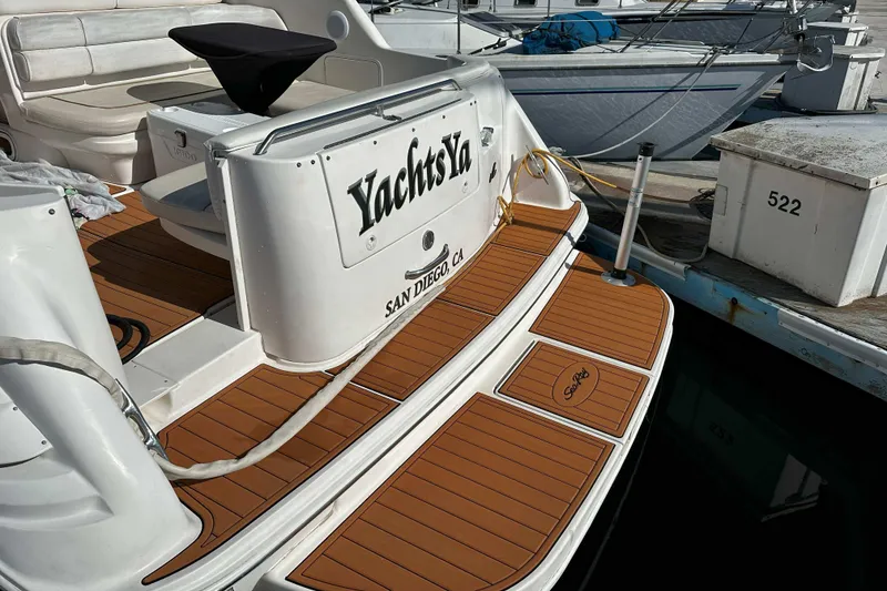 Slide: The Image of 1999 Sea Ray 330 Sundancer docked, featuring teak deck and San Diego registration. - 10