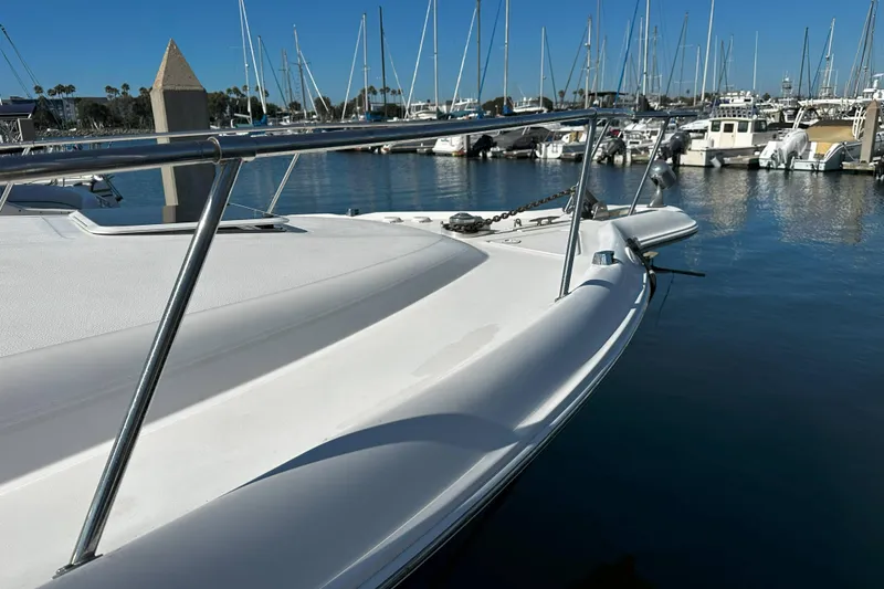 Slide: The Image of 1999 Sea Ray 330 Sundancer docked in a marina with sailboats in the background. - 2