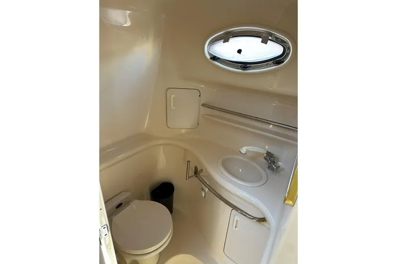 Slide: The Image of 1999 Sea Ray 330 Sundancer cabin interior with bed, pillows, and TV. - 26