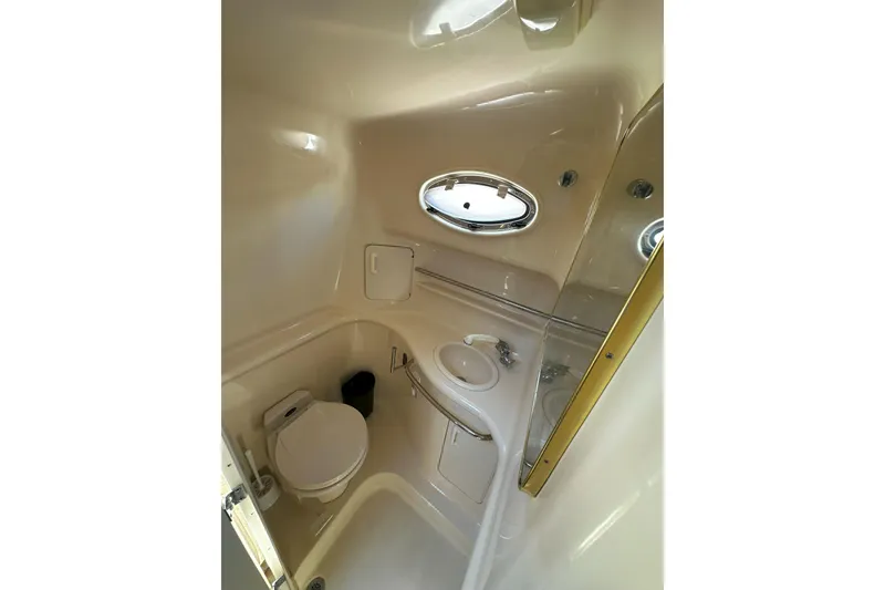 Slide: The Image of Interior cabin of 1999 Sea Ray 330 Sundancer with beige seating and blue pillows. - 27