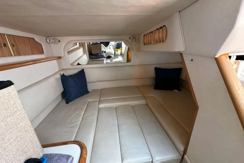 Slide: The Image of 1999 Sea Ray 330 Sundancer bathroom with toilet, sink, and porthole window. - 28