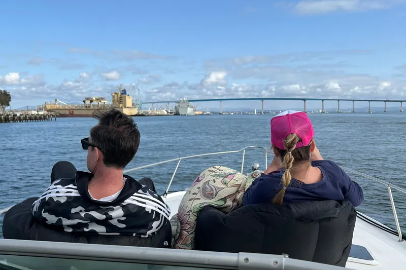 Slide: The Image of Two people relaxing on a 1999 Sea Ray 330 Sundancer, enjoying a scenic waterfront view. - 35