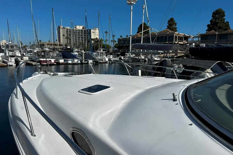 Slide: The Image of 1999 Sea Ray 330 Sundancer yacht docked in a marina with surrounding boats. - 4