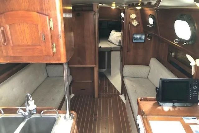 Slide: The Image of Interior of 1988 Pacific Seacraft 34 sailboat with wood finish and cozy seating. - 10