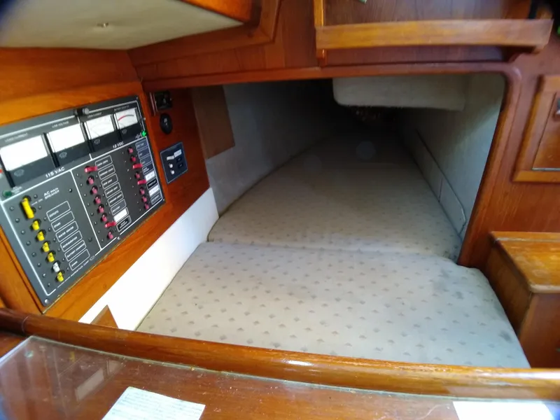 Slide: The Image of 1988 Pacific Seacraft 34 interior cabin with control panel and sleeping area. - 15