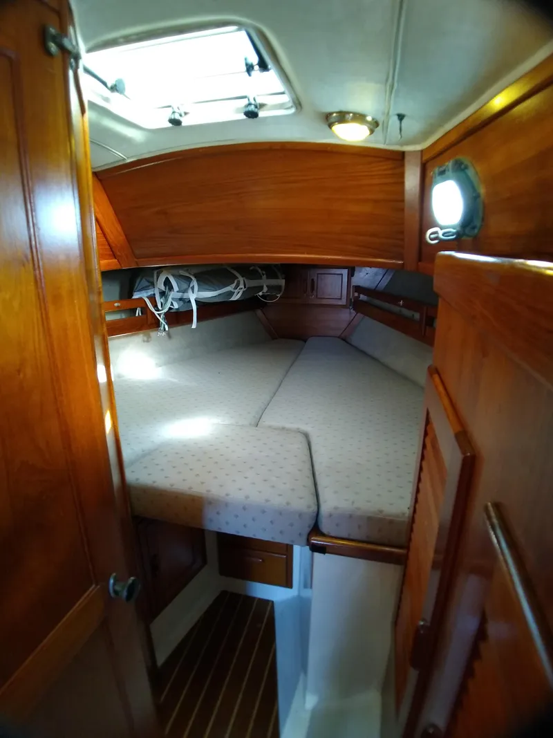 Slide: The Image of 1988 Pacific Seacraft 34 cabin interior with wooden finish and cozy sleeping area. - 16