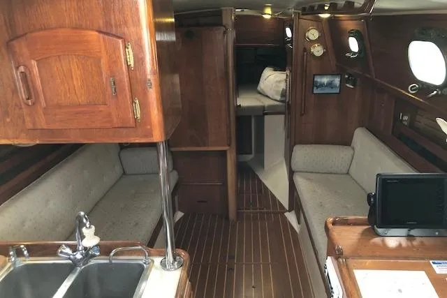 Slide: The Image of Interior of 1988 Pacific Seacraft 34 sailboat with wooden cabinetry and cozy seating. - 21