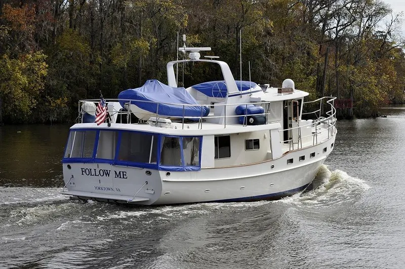 Slide: The Image of Kadey Krogen 48 yacht from 2001 cruising on a scenic river with autumn foliage. - 0