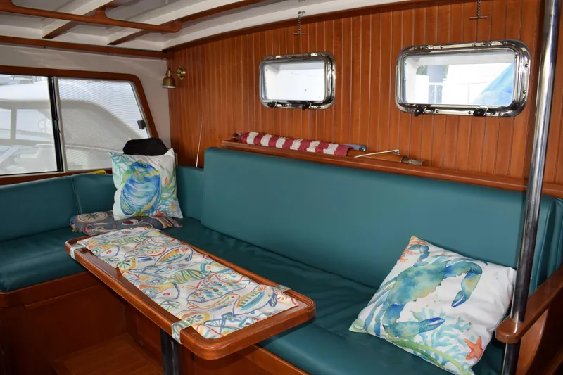 Slide: The Image of Interior of 2001 Kadey Krogen 48 yacht with teal seating and nautical-themed pillows. - 12