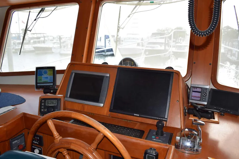 Slide: The Image of Kadey Krogen 48 helm station, 2001 model, featuring navigation equipment and wooden steering wheel. - 13