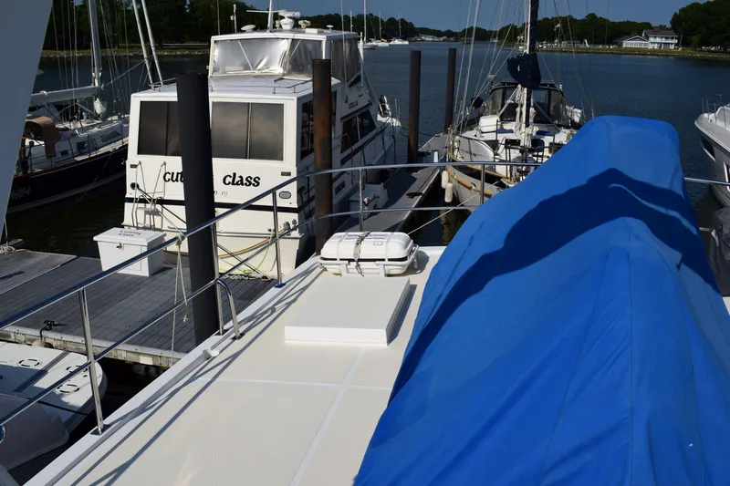 Slide: The Image of Docked Kadey Krogen 48 yacht, 2001 model, with blue cover and nearby boats. - 43