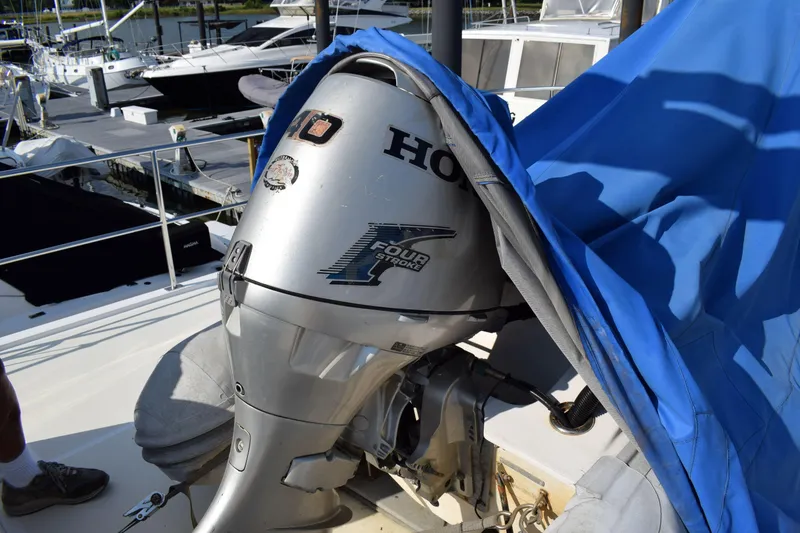 Slide: The Image of Outboard motor on 2001 Kadey Krogen 48 yacht, partially covered with blue tarp. - 47