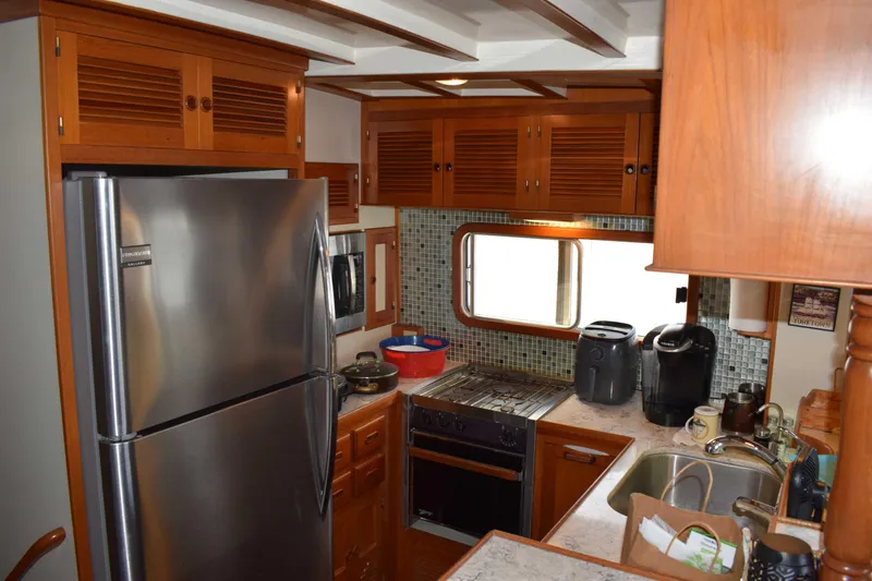 Slide: The Image of Kadey Krogen 48 yacht kitchen, 2001 model, featuring modern appliances and wooden cabinetry. - 6