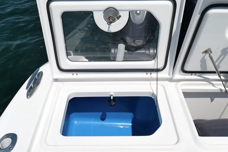 Slide: The Image of 2024 Everglades 395 Center Console boat with open storage compartment and visible engine. - 26