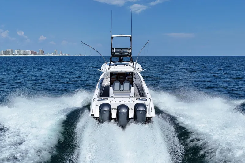 Slide: The Image of 2024 Everglades 395 Center Console boat cruising on open ocean with city skyline. - 4