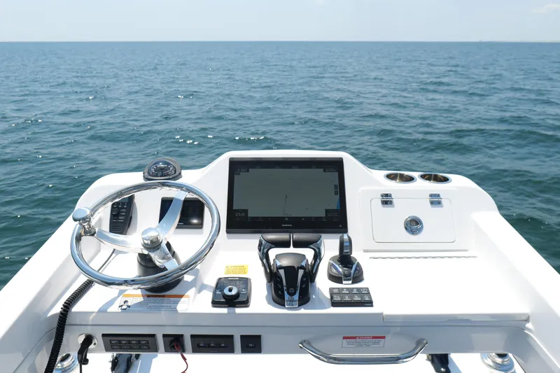 Slide: The Image of 2024 Everglades 395 Center Console helm with steering wheel and navigation screen on open water. - 41