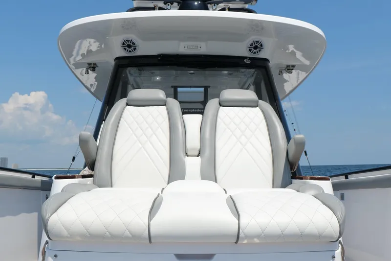 Slide: The Image of 2024 Everglades 395 Center Console boat with luxurious white seating and ocean backdrop. - 50