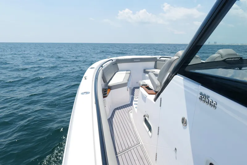 Slide: The Image of 2024 Everglades 395 Center Console boat on open sea, showcasing sleek design and seating. - 57