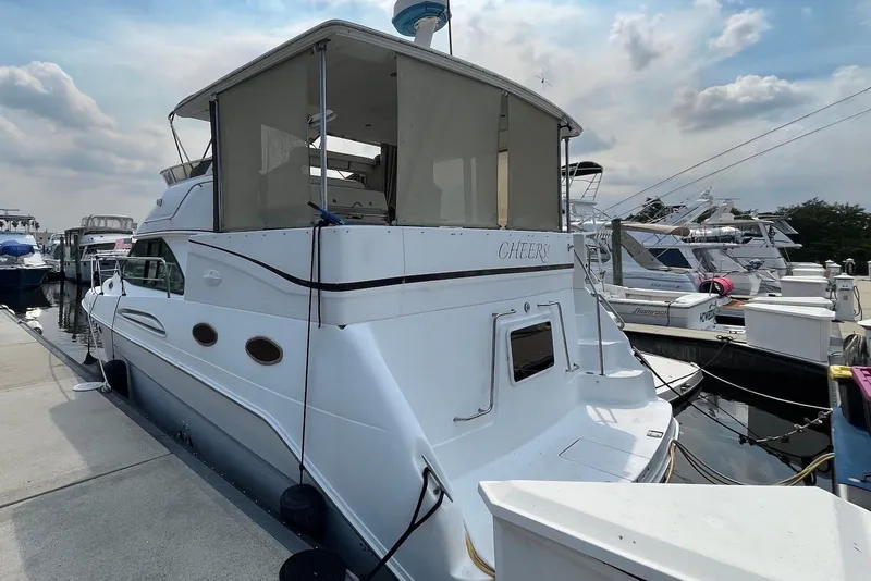 Slide: The Image of 1998 Sea Ray 370 Aft Cabin yacht docked at marina under cloudy sky. - 1