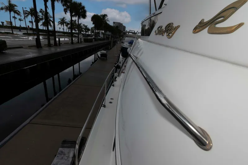 Slide: The Image of 1998 Sea Ray 370 Aft Cabin yacht docked by palm-lined waterfront. - 11