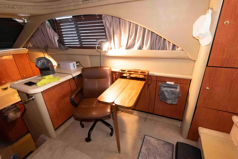 Slide: The Image of Interior of 1998 Sea Ray 370 Aft Cabin with wooden cabinetry and office setup. - 13