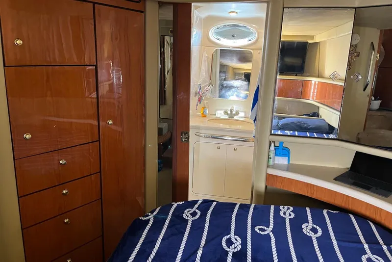 Slide: The Image of Interior of 1998 Sea Ray 370 Aft Cabin with wood cabinetry and nautical-themed bedding. - 20