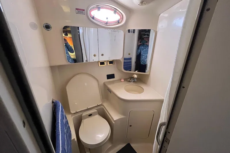 Slide: The Image of 1998 Sea Ray 370 Aft Cabin bathroom with toilet, sink, and mirror. - 22