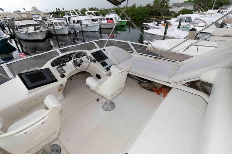 Slide: The Image of 1998 Sea Ray 370 Aft Cabin yacht interior with helm, seating, and marina view. - 5