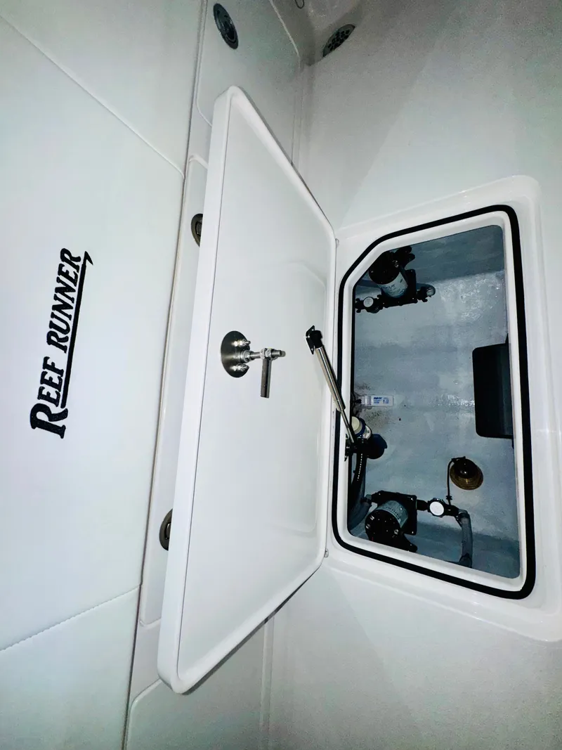 Slide: The Image of Reef Runner 230 c 2026, open storage compartment in boat. - 26