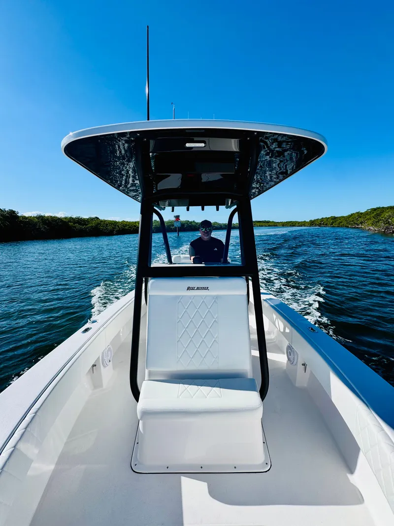 Slide: The Image of Reef Runner 230 c boat on calm water, 2026 model. - 4