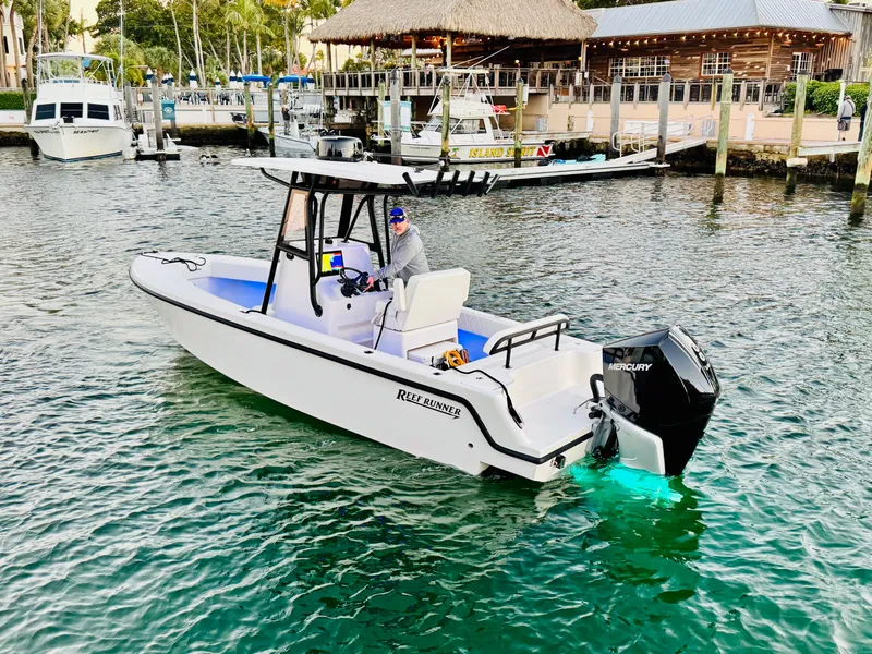 Slide: The Image of Reef Runner 230 c boat 2026 in harbor, featuring Mercury engine. - 6