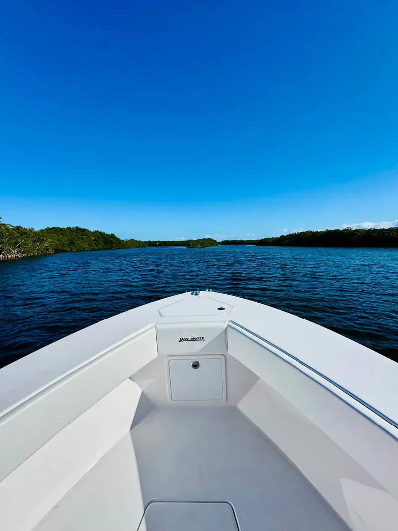Slide: The Image of Reef Runner 230 c boat on calm waters, 2026 model. - 8