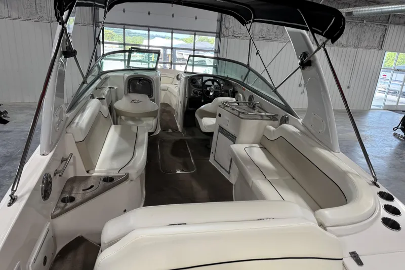 Slide: The Image of 2008 Rinker 296 Captiva Bowrider interior with white seating and black canopy in a showroom. - 12