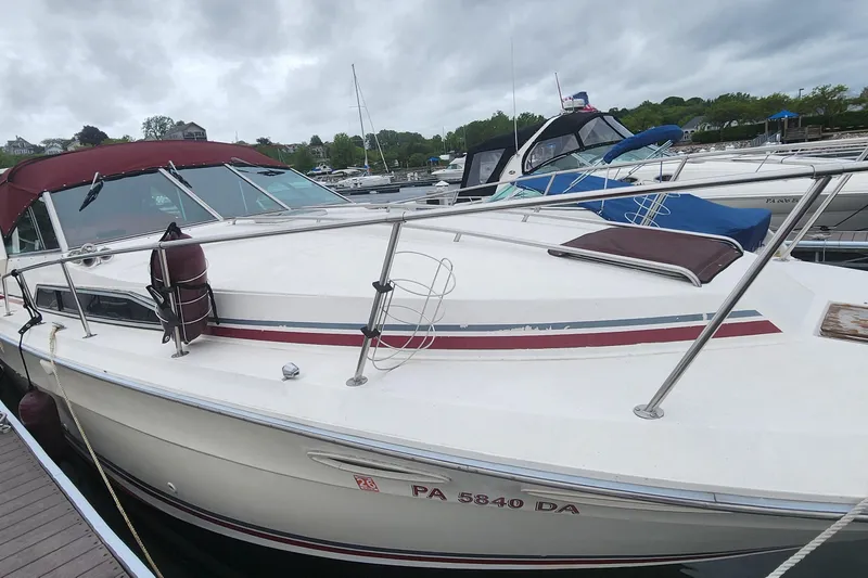 Slide: The Image of 1987 Sea Ray 340 Sundancer docked at marina under cloudy skies. - 0
