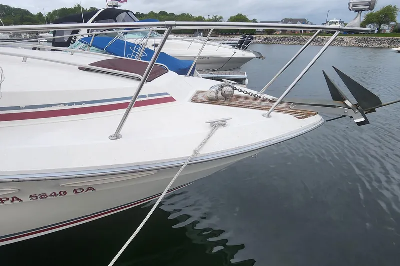 Slide: The Image of 1987 Sea Ray 340 Sundancer docked, featuring anchor and bow details. - 1