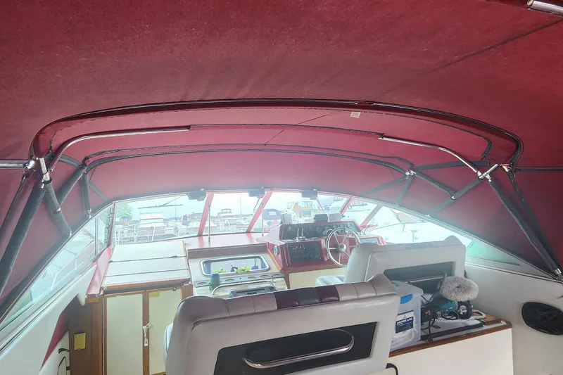 Slide: The Image of Interior view of 1987 Sea Ray 340 Sundancer boat with red canopy and helm station. - 15