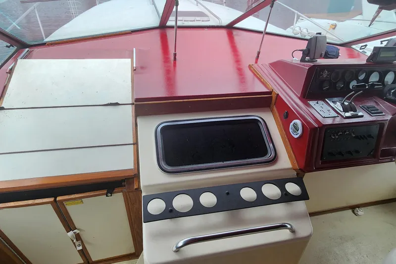 Slide: The Image of 1987 Sea Ray 340 Sundancer helm with controls, gauges, and storage compartments. - 2
