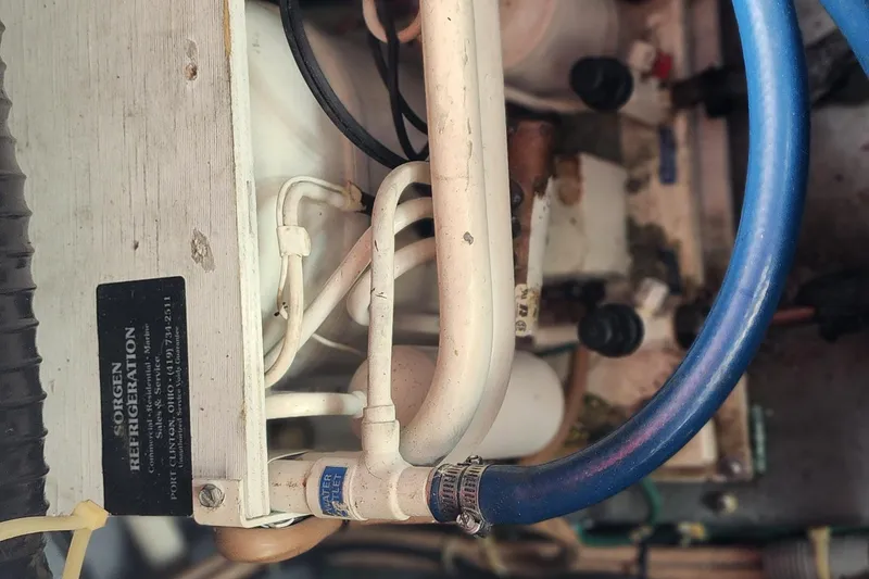 Slide: The Image of Engine compartment of a 1987 Sea Ray 340 Sundancer with visible hoses and refrigeration unit. - 28